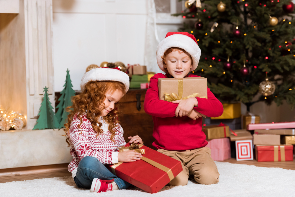 Enfants avec chapeaux de père noël et des cadeaux