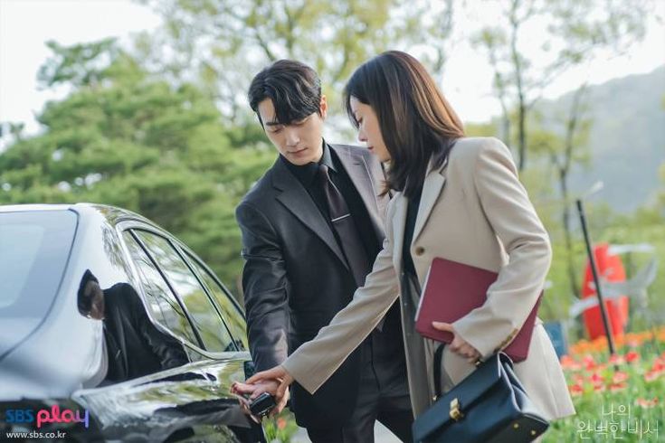 This  contain  Love Scout producer standing next to each other near a car