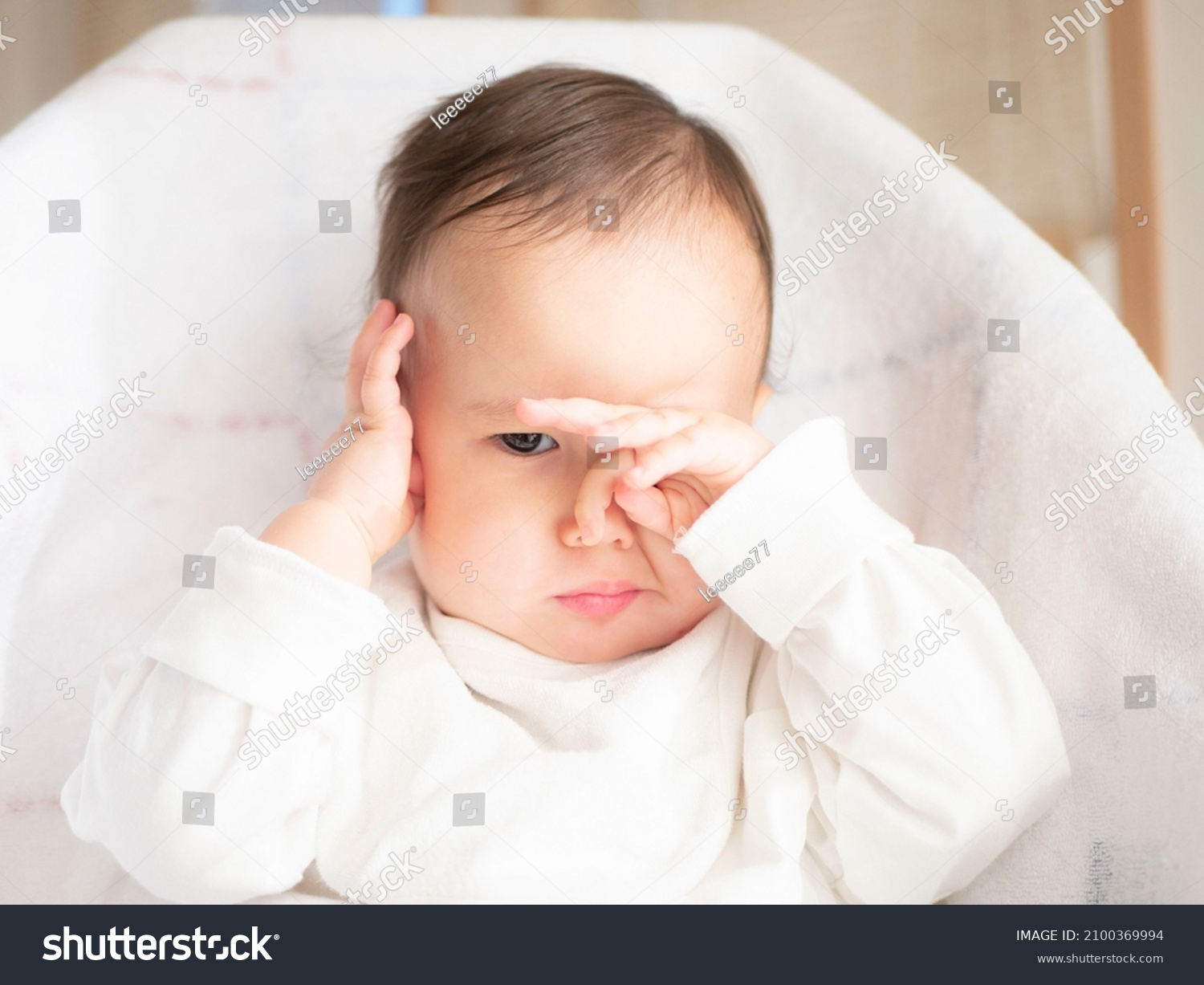 Bebé frotándose los ojos, posible signo de irritación ocular o molestia visual.
