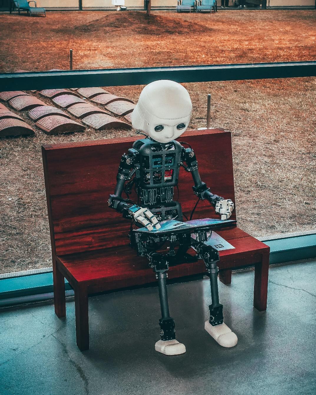 A robot sitting on a bench

Description automatically generated