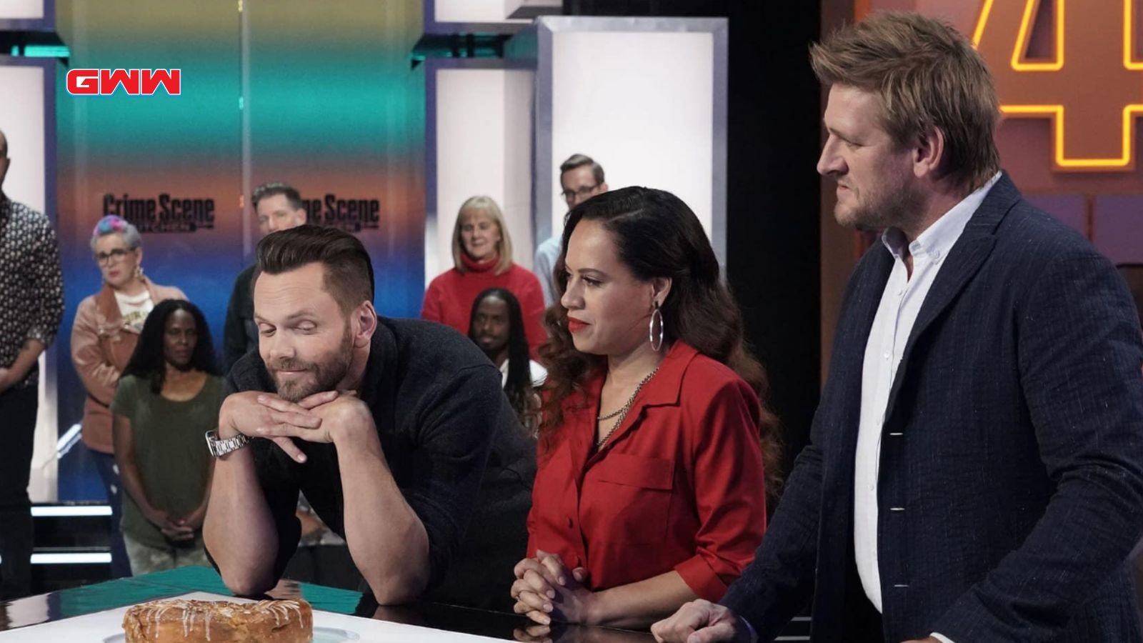 Host Joel McHale with judges Curtis Stone and Yolanda Gampp discussing dessert.