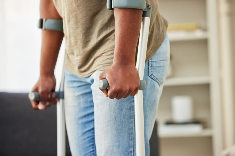 A man uses crutches to help maintain his balance after a car accident caused hip pain and difficulty walking for him. 