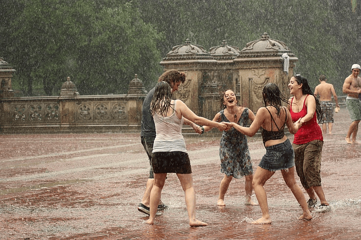 Rain photoshoot featuring a group enjoying in rain, happy and  laughing with joy.