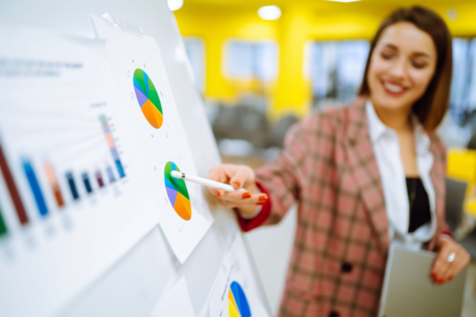 Women pointing at a graph with a pen and smiling. 