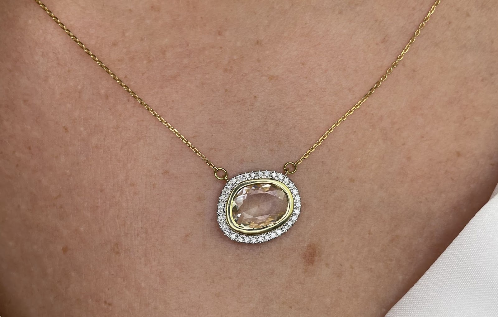 A light pink sapphire slice necklace on a model, the perfect summer accessory.