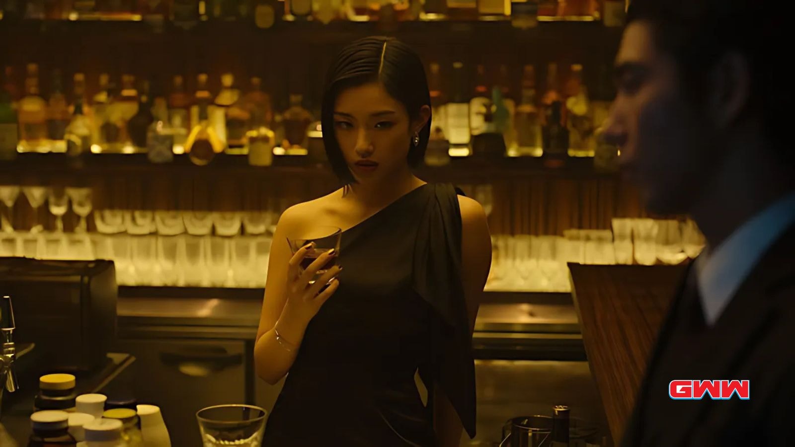 Misato Morita as Aiko, holding a drink in a dimly lit bar.