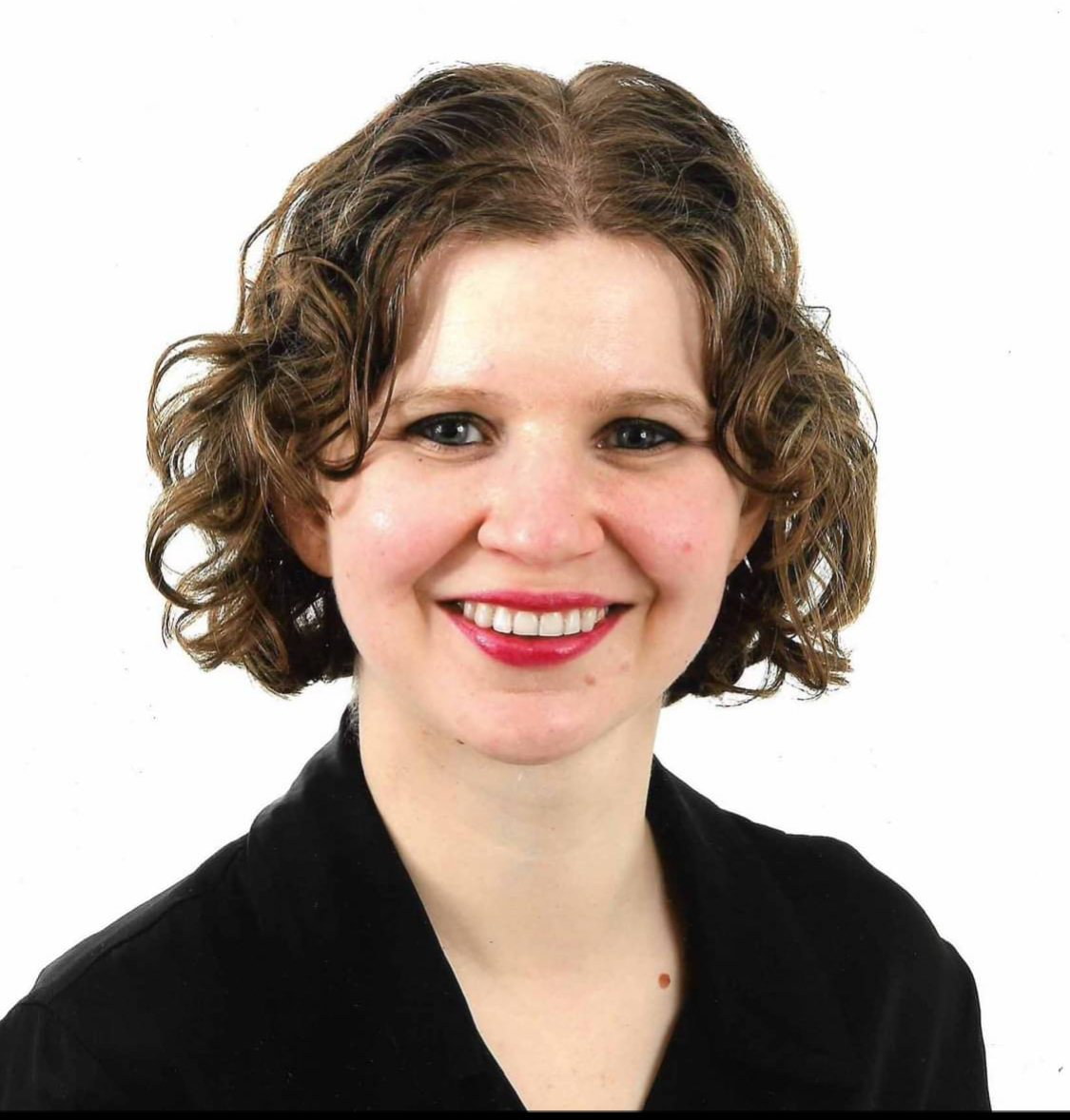 A woman poses for a portrait. White background. 