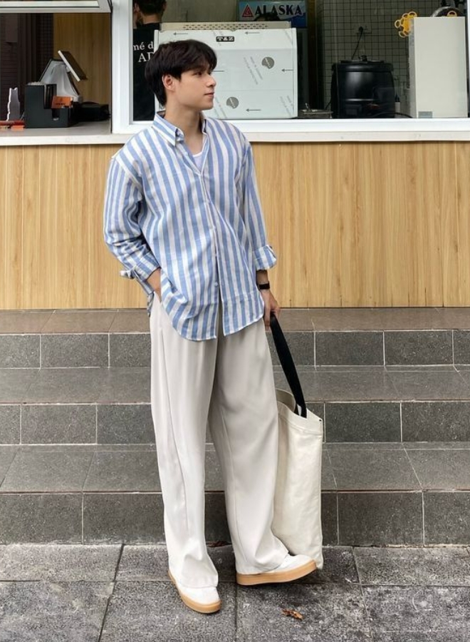 Pria dengan kemeja bergaris dan celana beige.