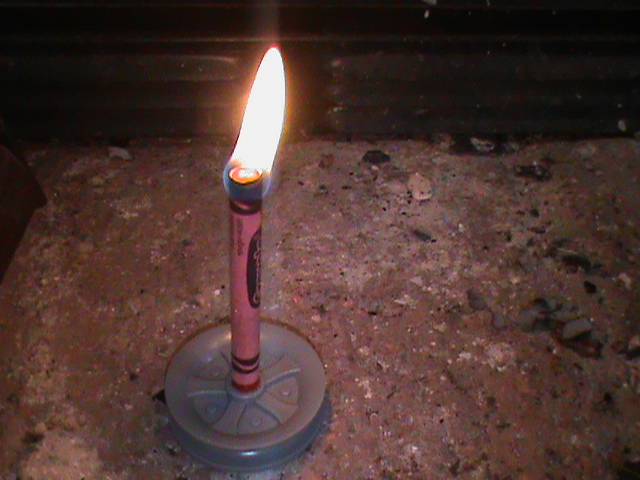 Crayon lighted up functioning as a candle as a Survival Hacks Using Common Household Items 