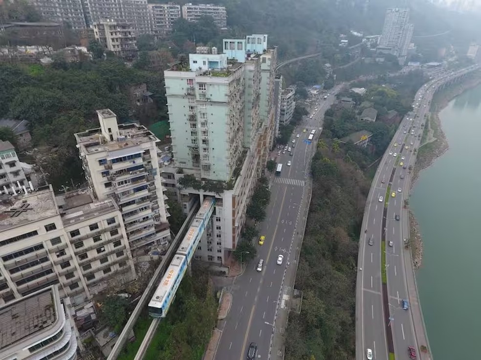 O trem passa por um edifcio residencial sem interromper a vida cotidiana, um exemplo da harmonia entre a inovao urbana e a densidade populacional  Foto: La Nacion via Getty Images