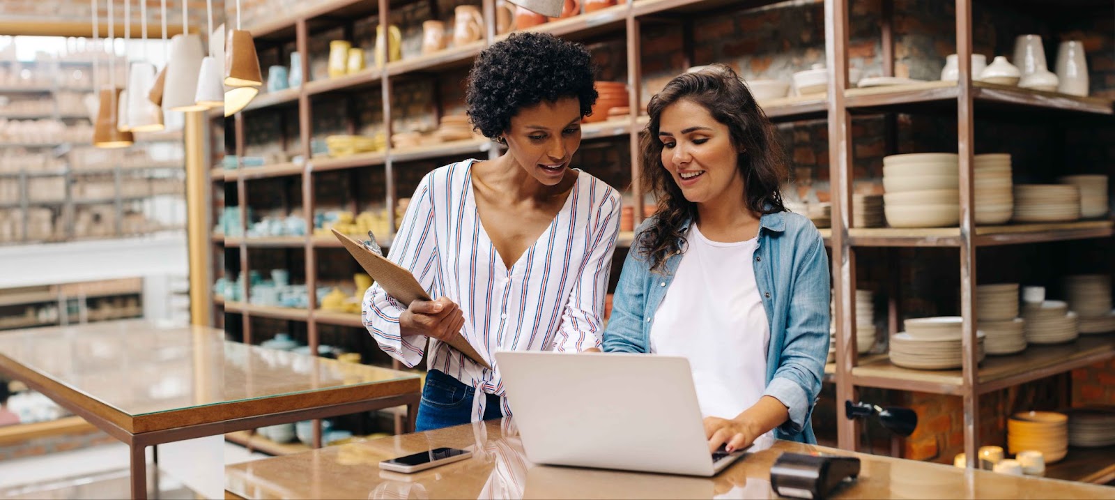 two women looking over a computer screen in a retail store