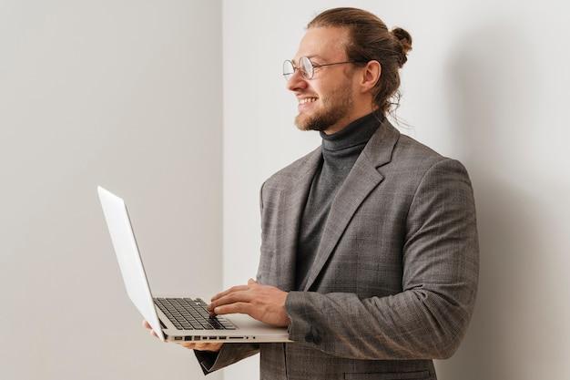 Medium shot smiley man holding laptop