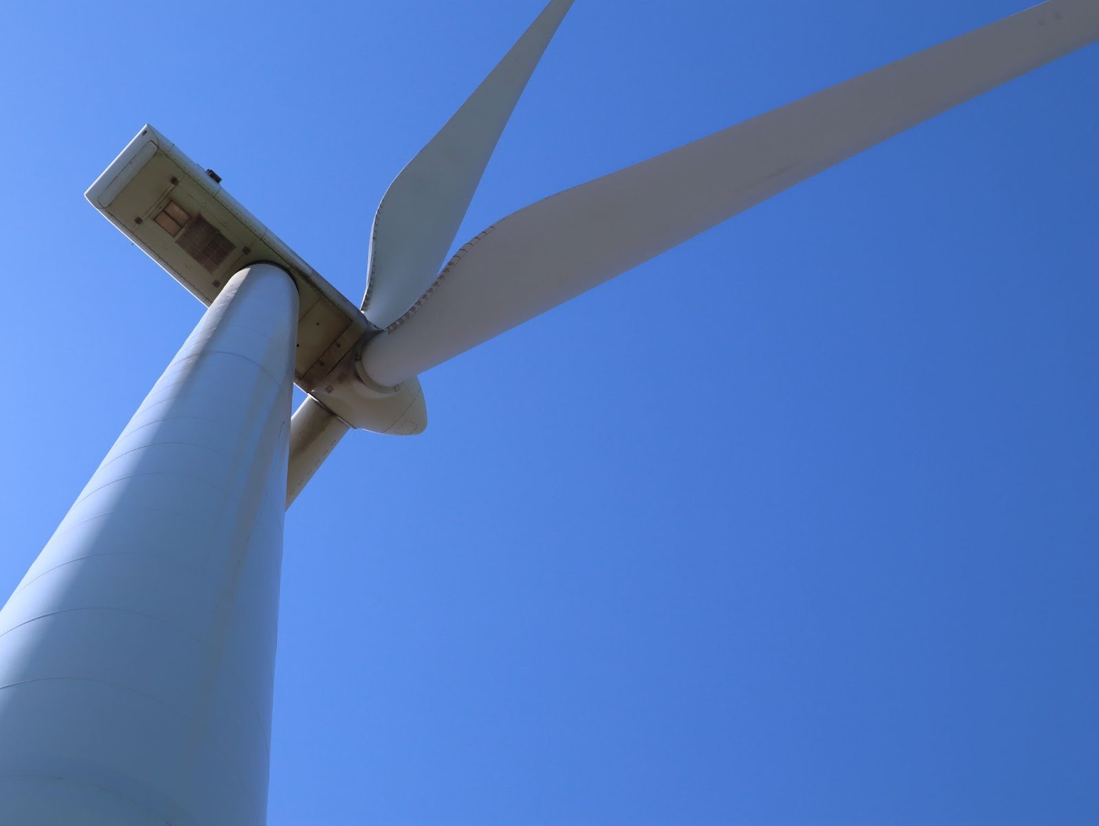 Close-up view looking up at a wind turbine used in Pinnacle Career Institute’s Wind Turbine Technician training program. Hands-on wind energy training at a hybrid trade school prepares students for careers in renewable energy and wind turbine maintenance.