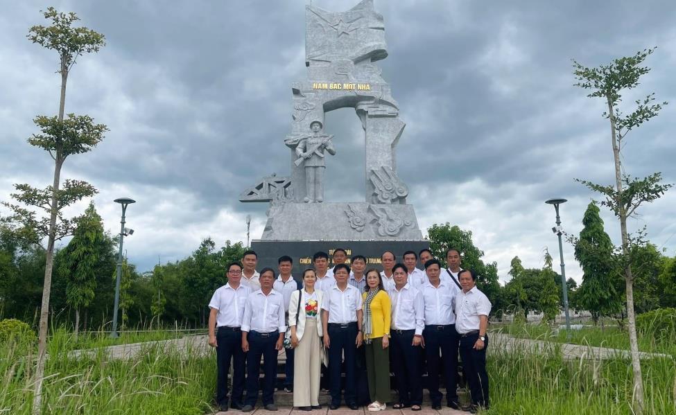 A group of people posing for a photo in front of a statueDescription automatically generated