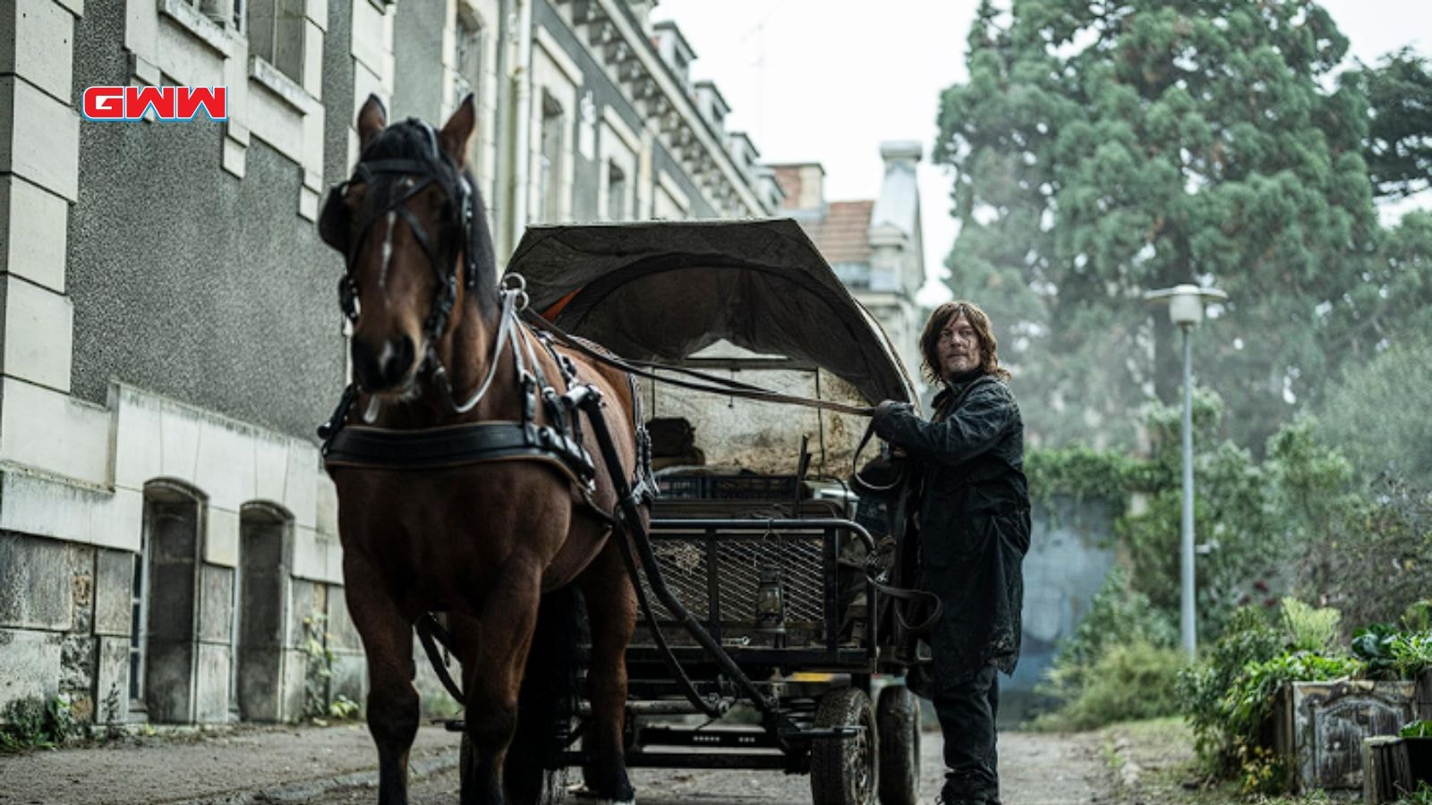 Norman Reedus as Daryl Dixon standing by a horse and cart