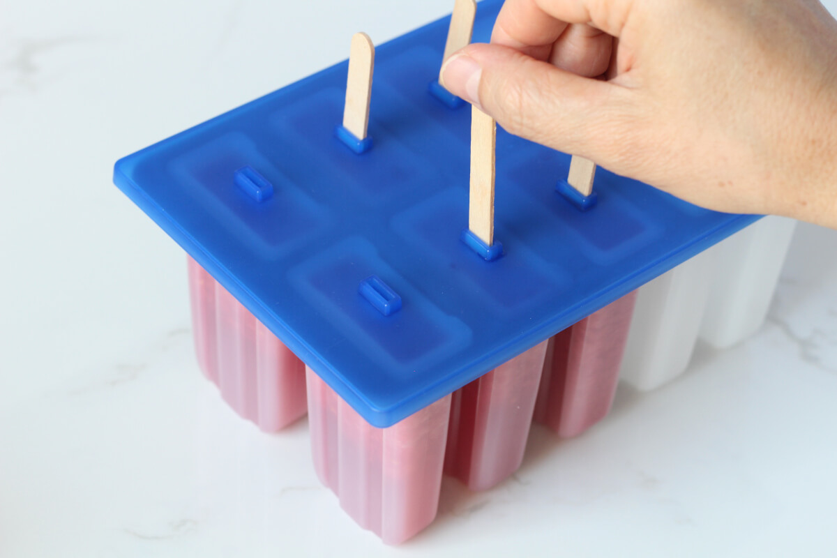 Inserting sticks into popsicle tray