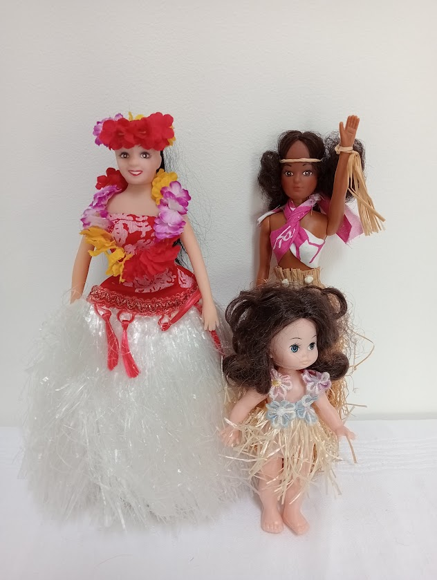 Hawaiian dolls wearing grass skirts and flower leis