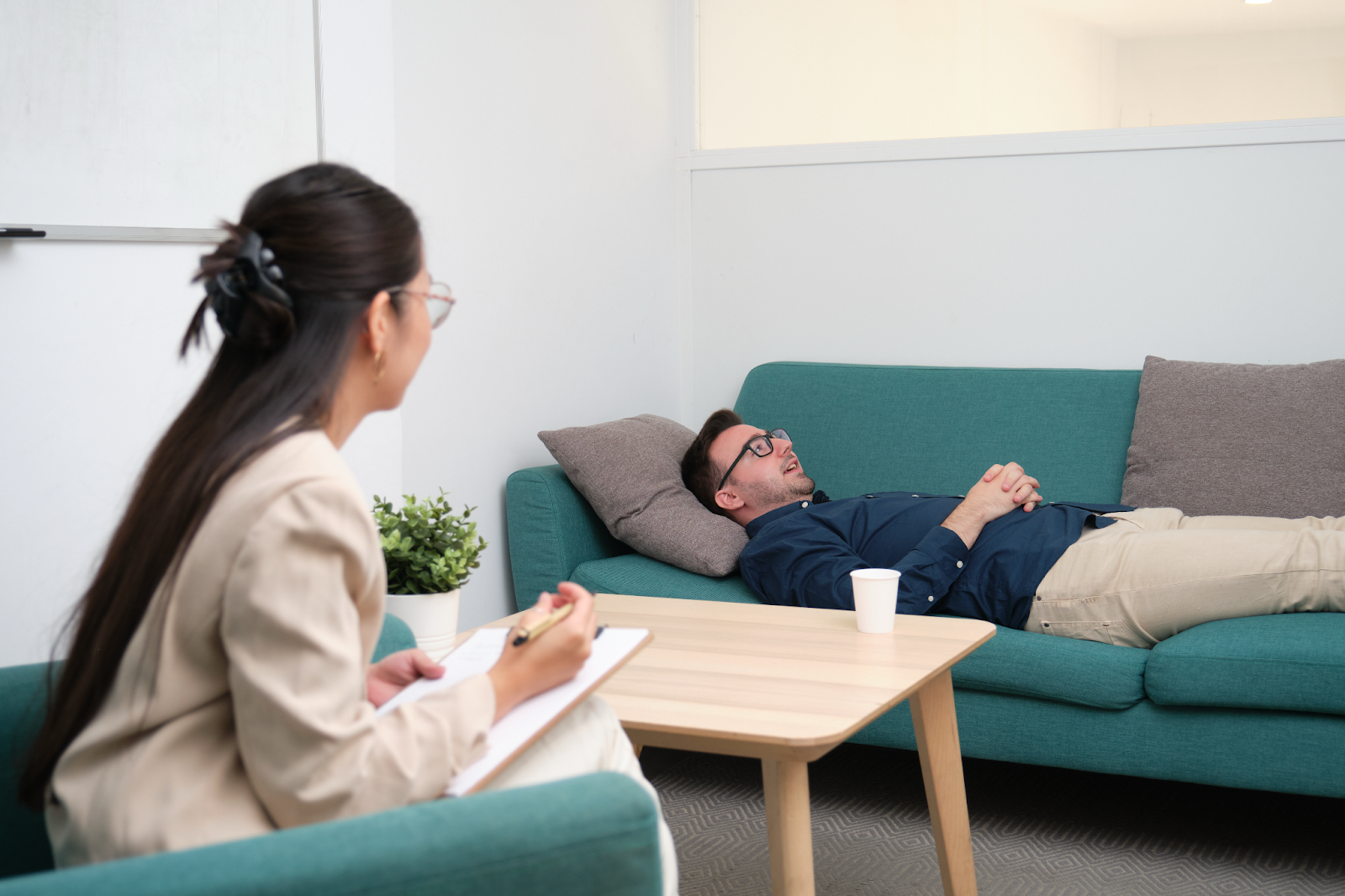 A man lying on a couch and receiving therapy.