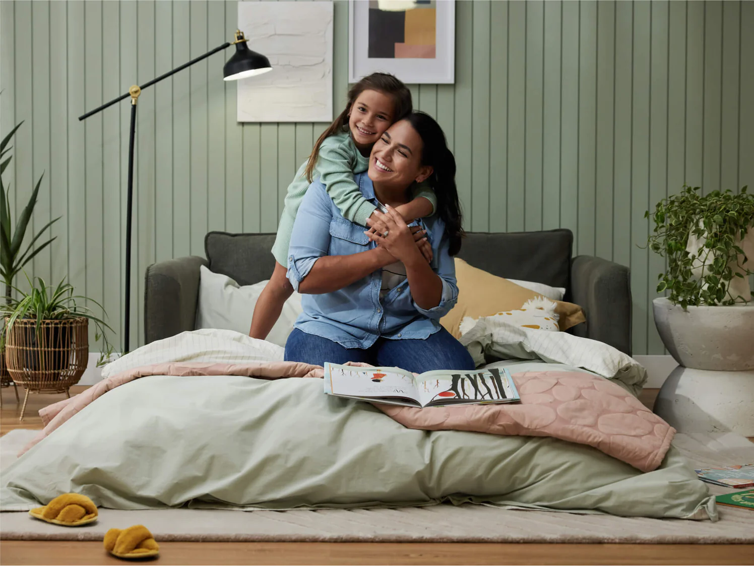 mother and daughter hugging on cosy sofabed