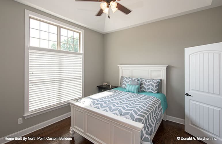 Another bedroom with gray walls and a white bed matching the door.