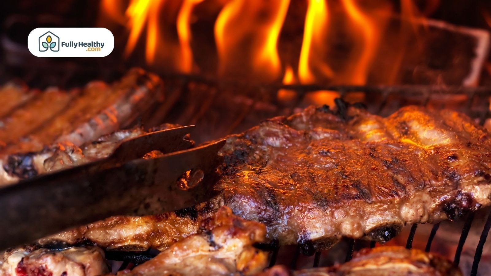 Grilling baby back ribs over open flame with metal tongs