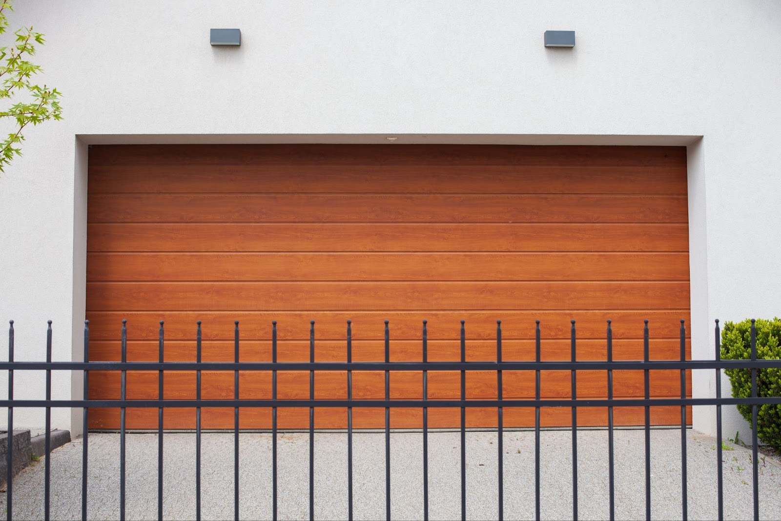 Aluminum fencing in front of a wood garage door. 