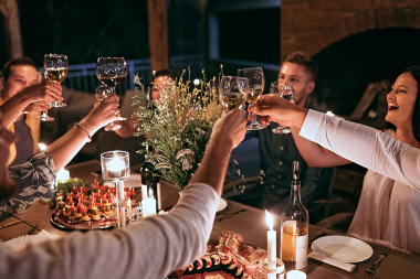 signs your outdoor living space is ready for a remodel family and friends toasting during patio dinner custom built michigan