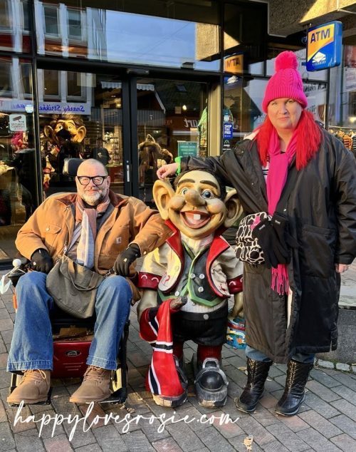 man and woman having a picture with a Norwegian Troll