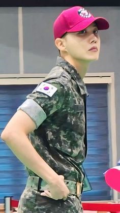 This  contain an image ofJ-Hope, in uniform holding a pink frisbee and looking off to the side