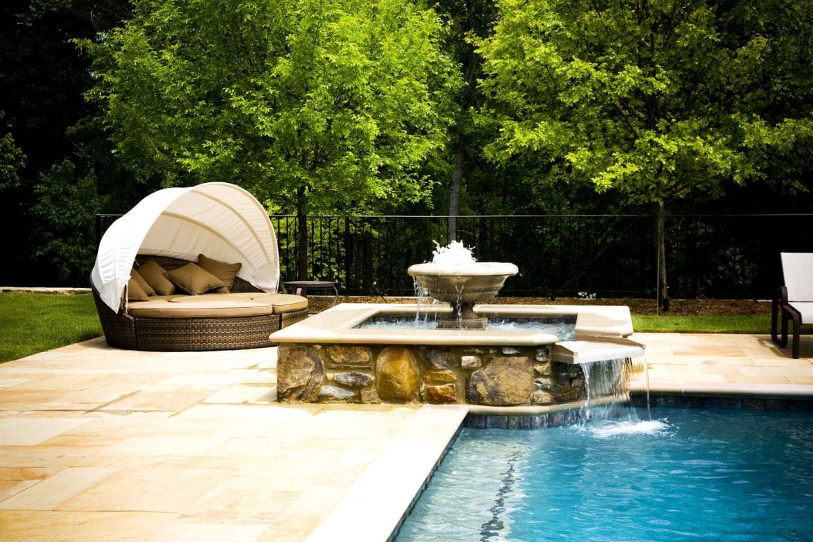 A fountain that cascades into a pool that requires luxury home maintenance to keep its beauty vibrant.