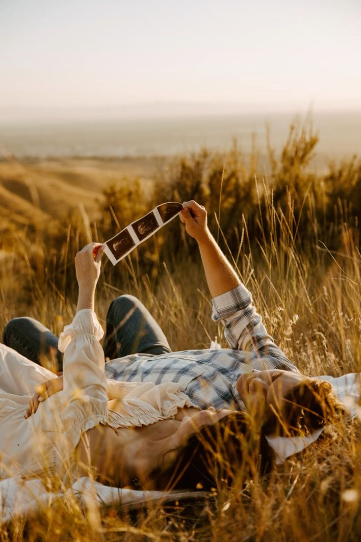 Golden hour nostalgia: Expecting parents admiring pictures in nature.