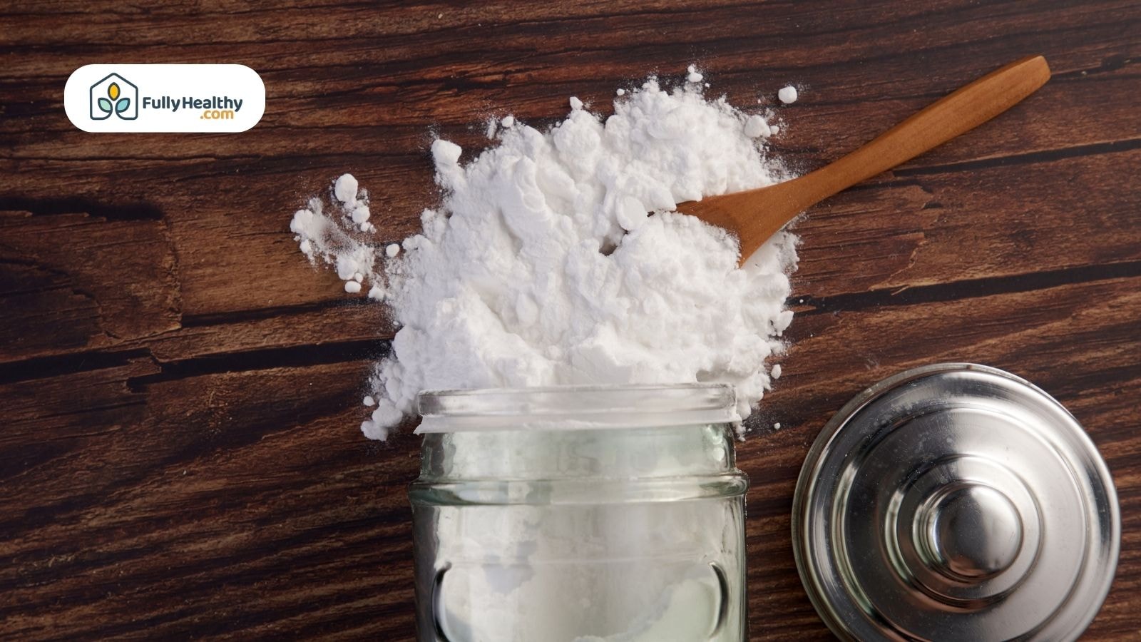 Baking soda spilled with a wooden spoon nearby