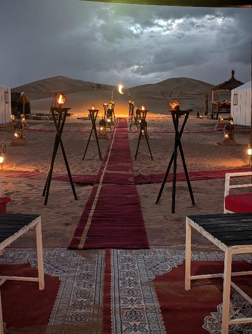 A red carpet with chairs and tables in the middle of a desert

AI-generated content may be incorrect.