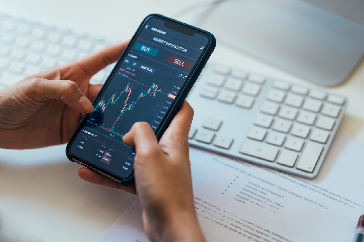 pessoa segurando celular com gráfico de price action