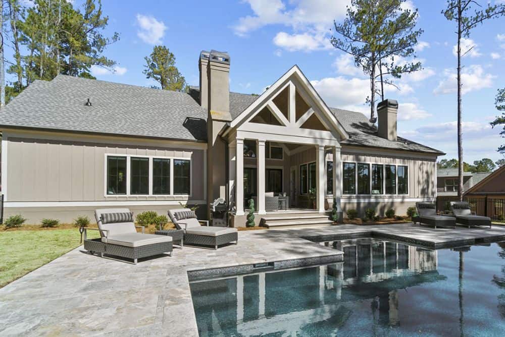 Pool deck with wicker lounge chairs accentuated with striped pillows.