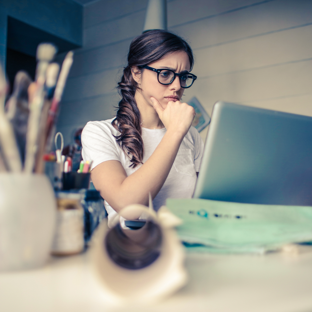 Woman looking at computer with a thoughtful expression on her face