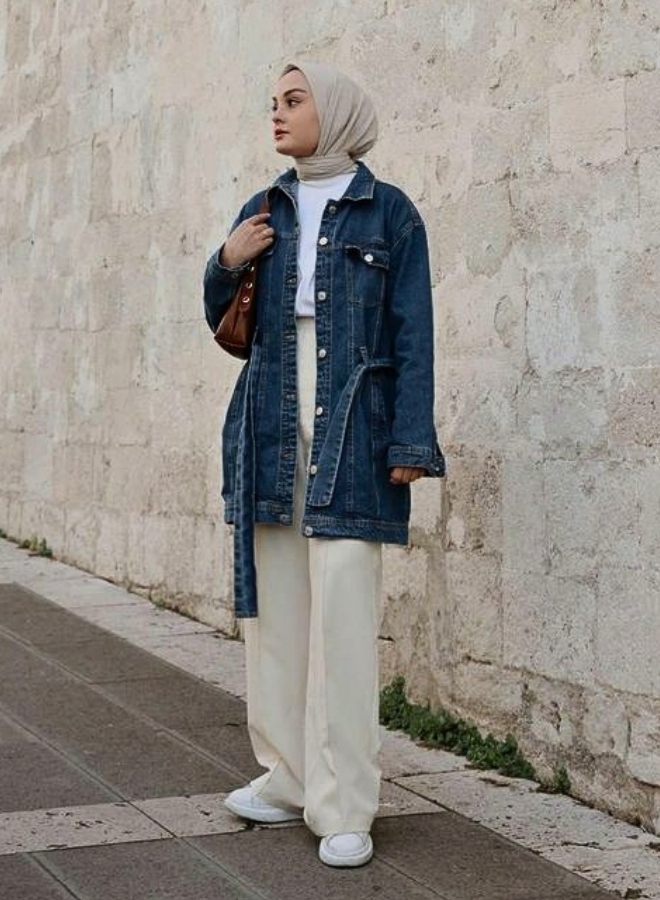 Wanita dengan baju denim navy dan jilbab beige.