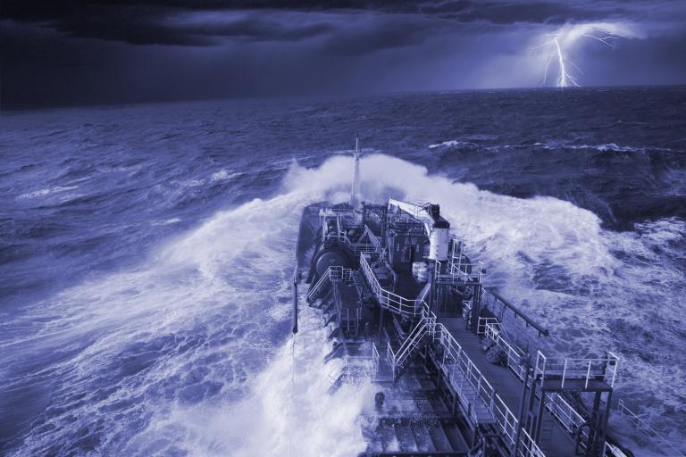 A ship in rough seas navigates through dark, stormy conditions with lightning flashing in the distant sky.