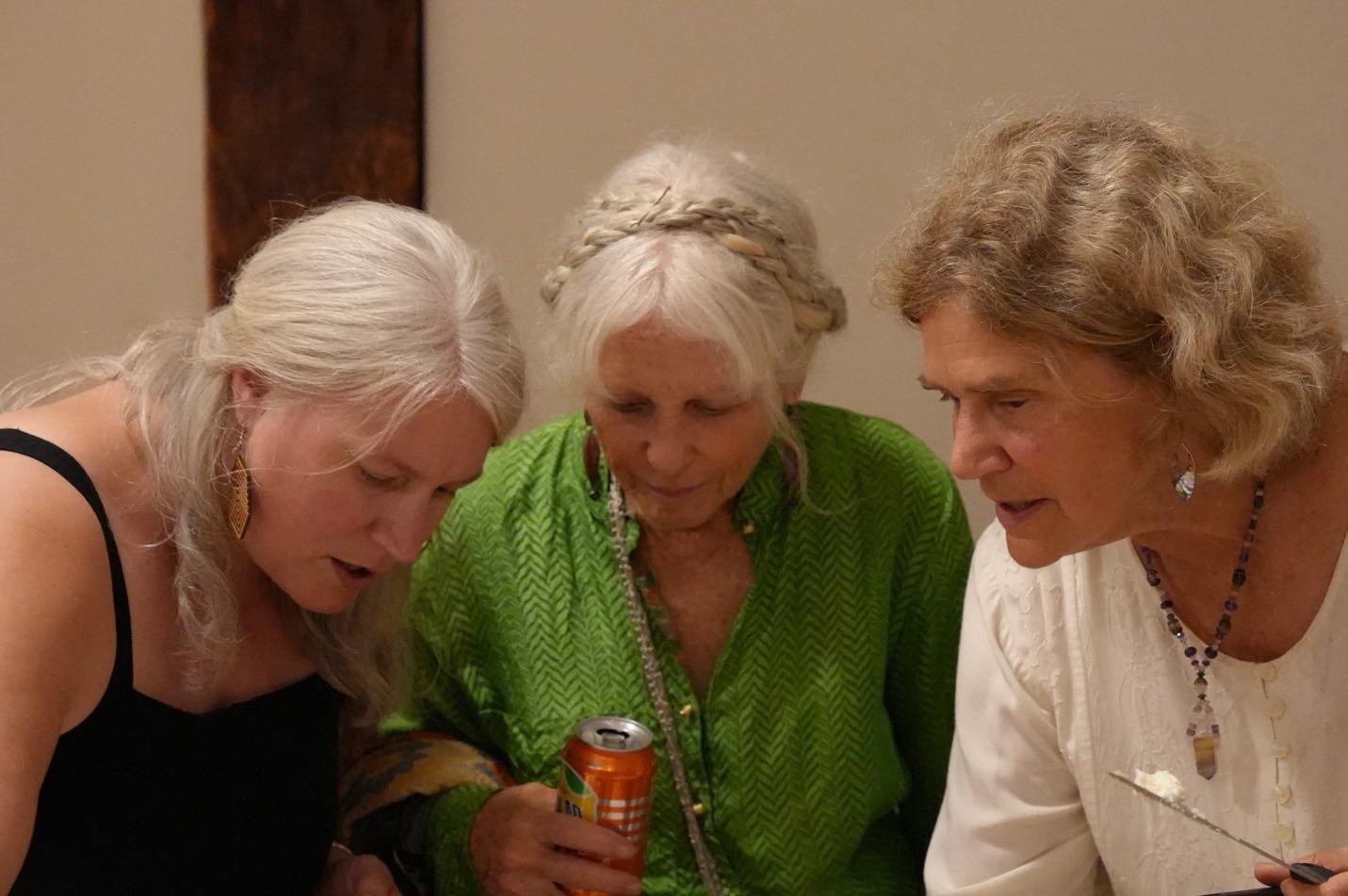 A group of women looking at a can

Description automatically generated