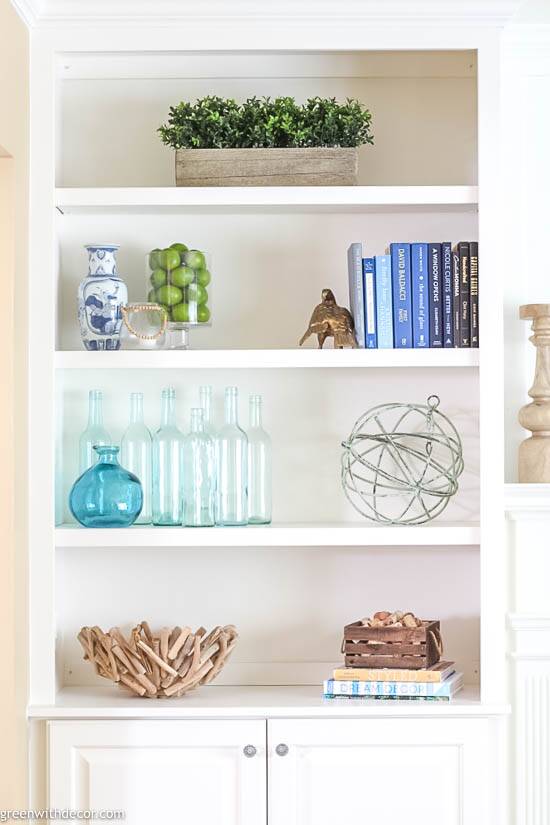 a shelf with books and vases