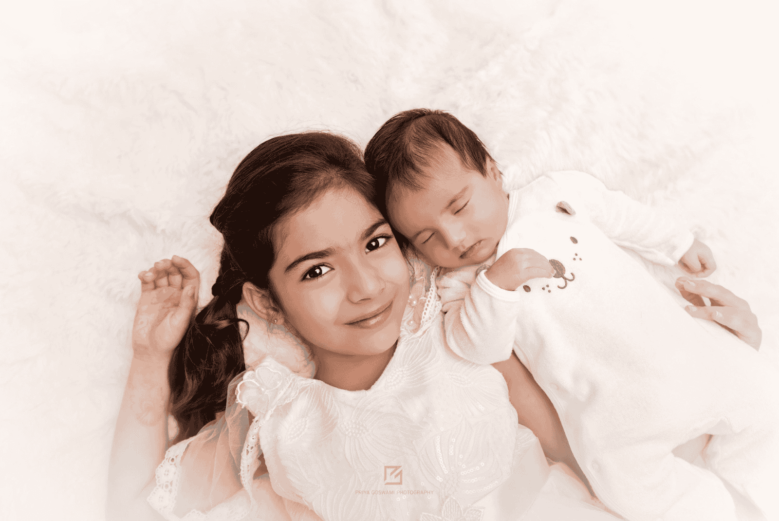 Adorable newborn photoshoot featuring a newborn and sibling lying next to each other with heads touching, capturing heartfelt expressions.