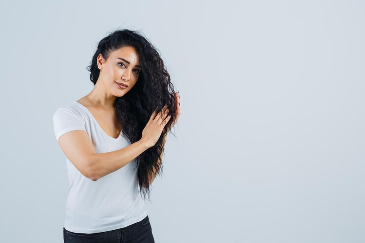 Beautiful woman in a white t-shirt following hair care routine