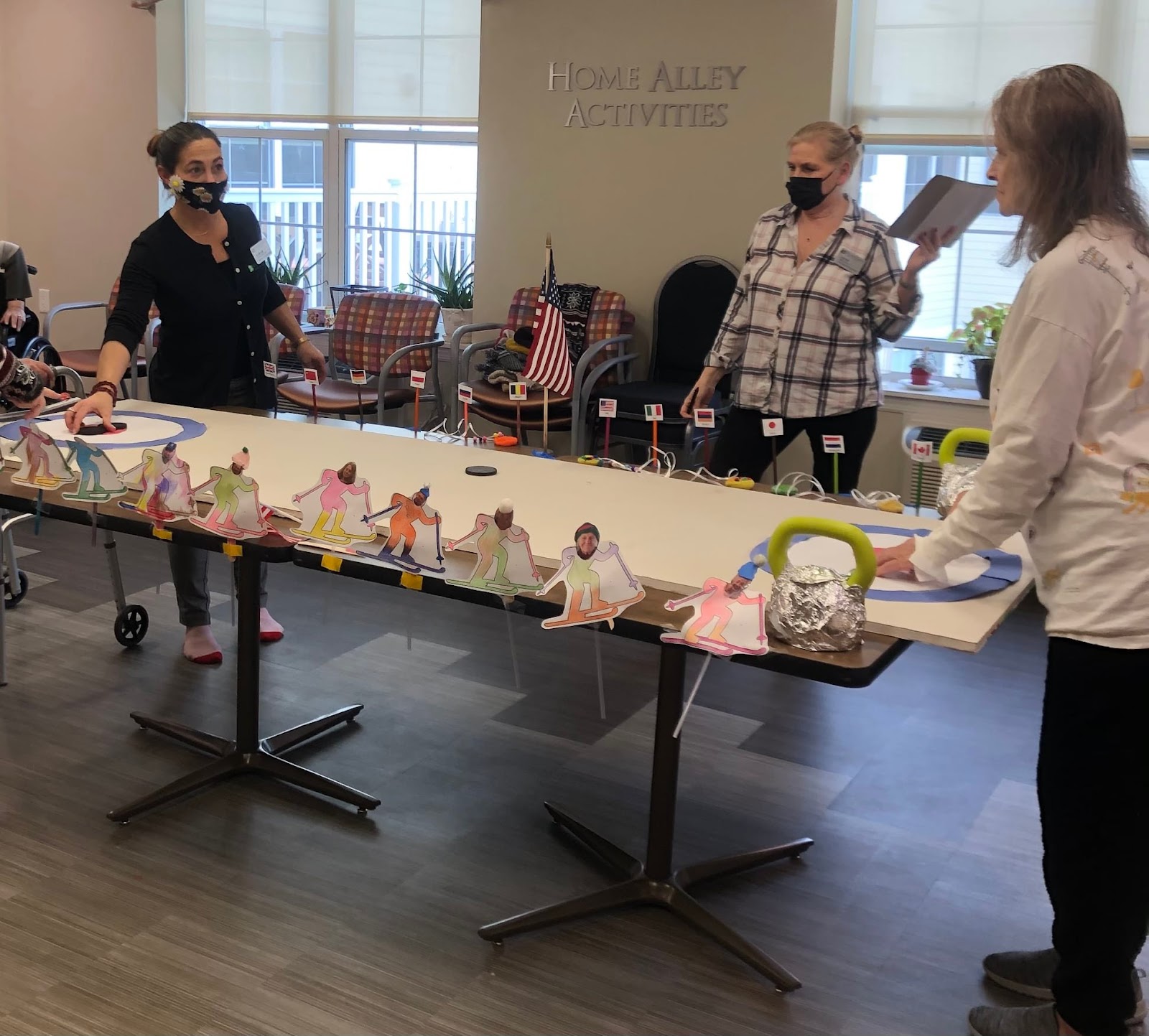 Village Green senior living staff wearing masks and setting up a make-shift hockey table