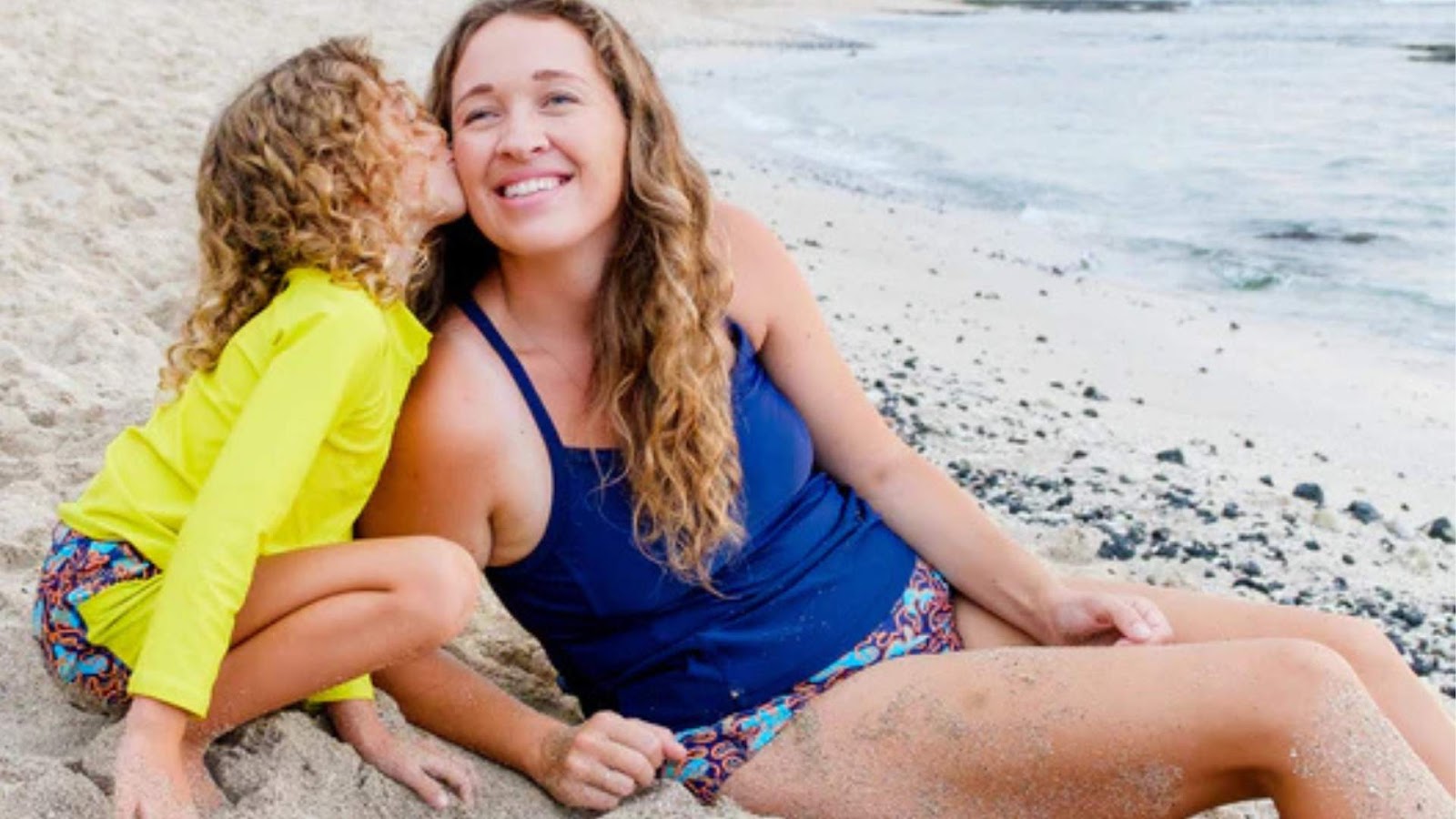 Woman with her child on the beach in the SwimZip mix and matched swimwear—How to mix and match swimsuits: Your complete style guide