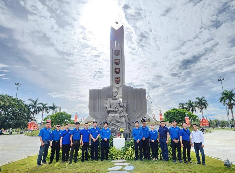 A group of people standing in front of a statueDescription automatically generated