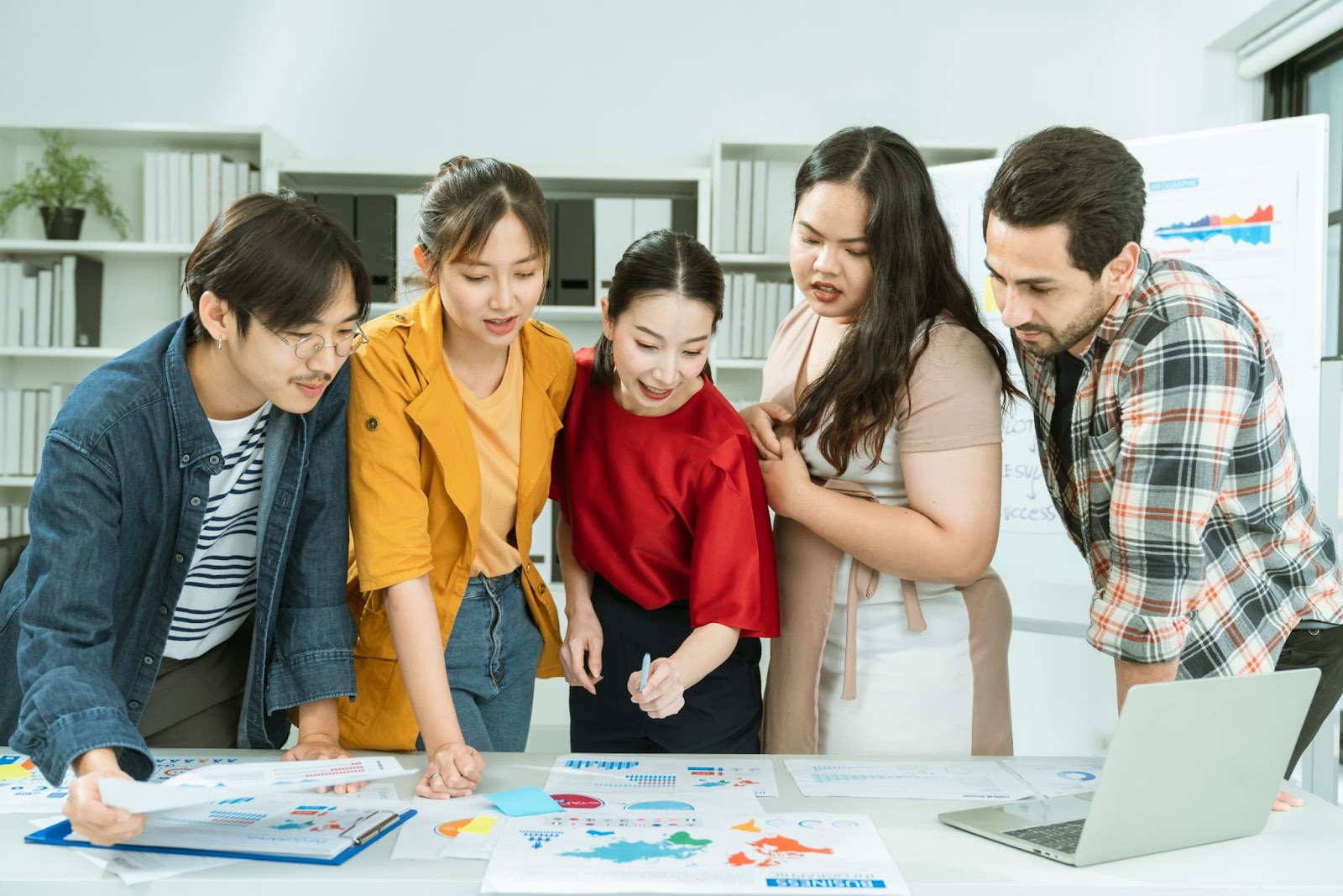 Personas revisando mapas en una reunión