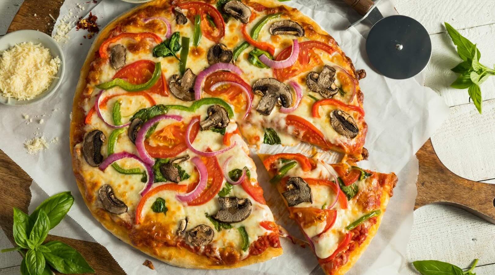 Homemade veggie pizza topped with mushrooms, red and green peppers, red onions, and fresh spinach, served on a crispy crust. This colorful and healthy pizza is a delicious option for those looking for a nutritious meal in Mississauga, recommended by our registered dietitian.