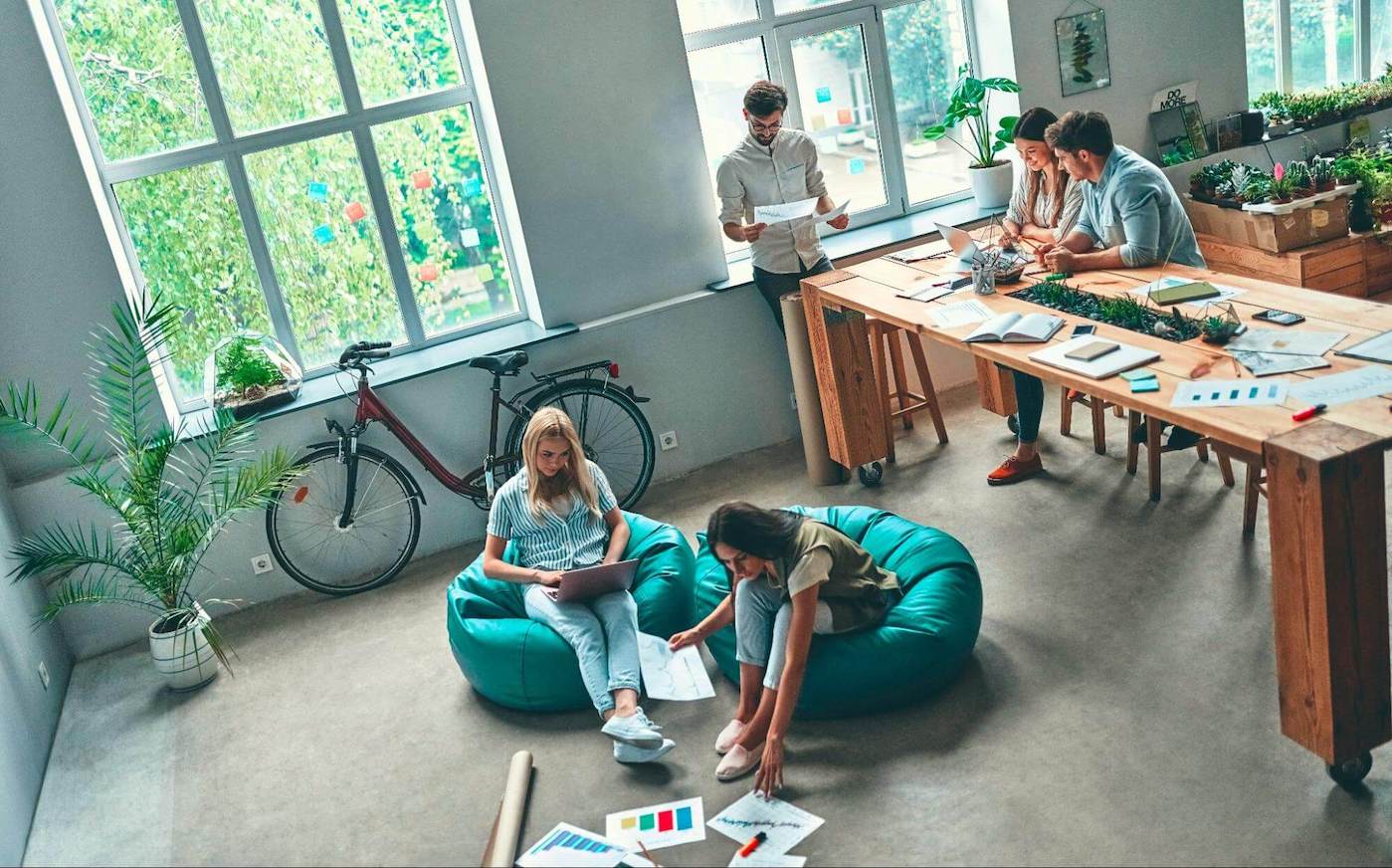 Group of people working together in an open workspace with a wooden table