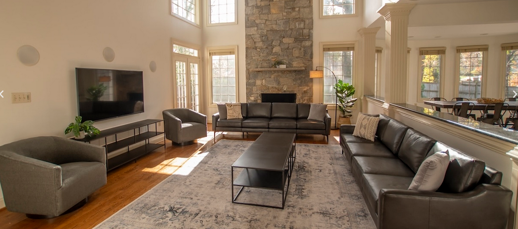 Spacious living room at AMFM facility in Virginia featuring modern furniture, a stone fireplace.