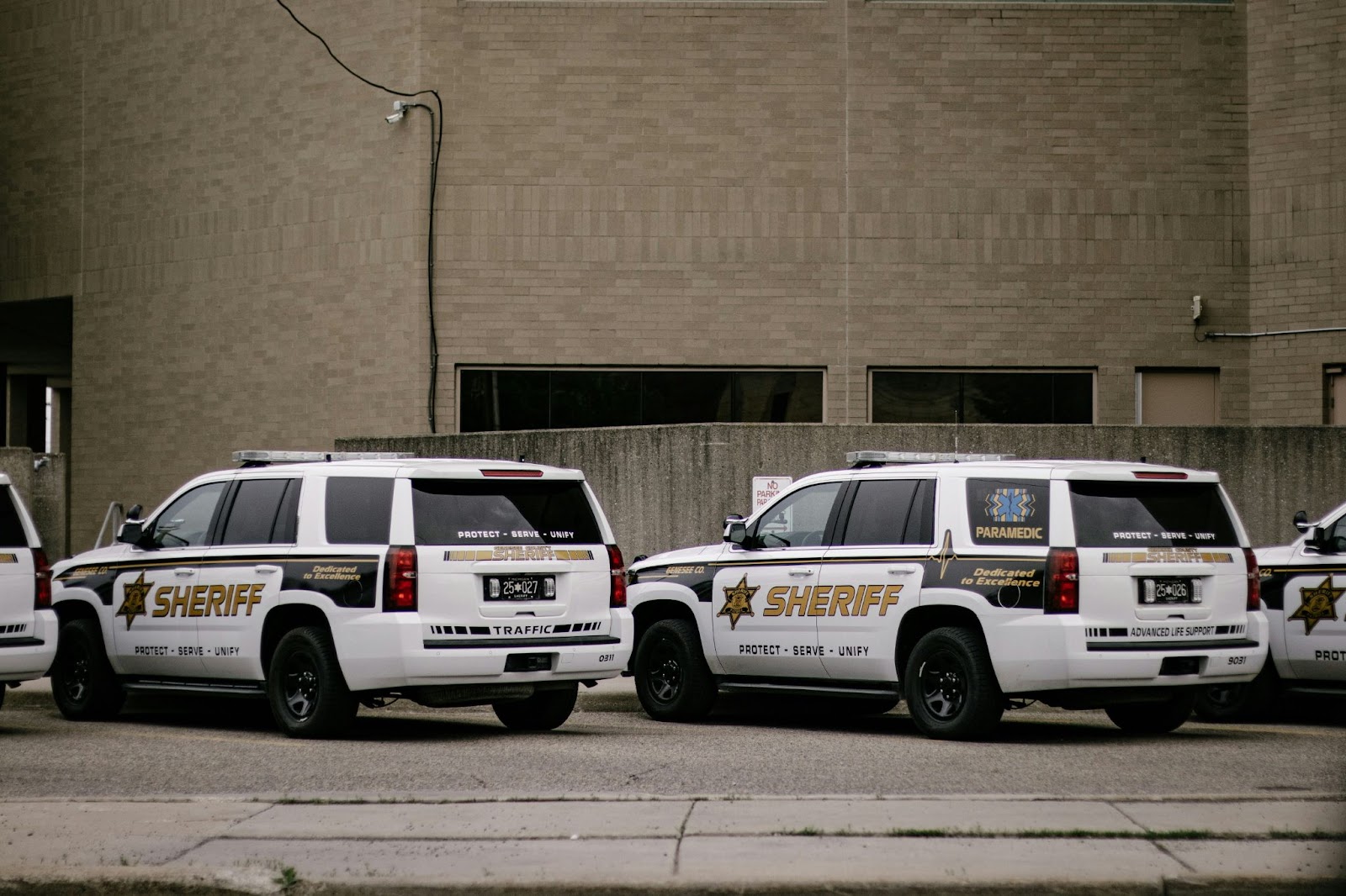 Sheriff's vehicles parked outside a concrete building